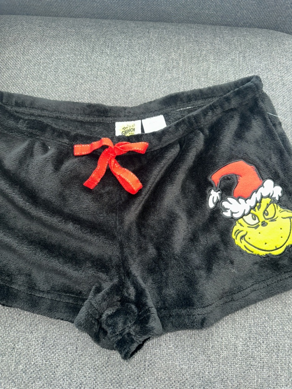 Plush Grinch Women's Lounge Shorts in Black with Red Bow